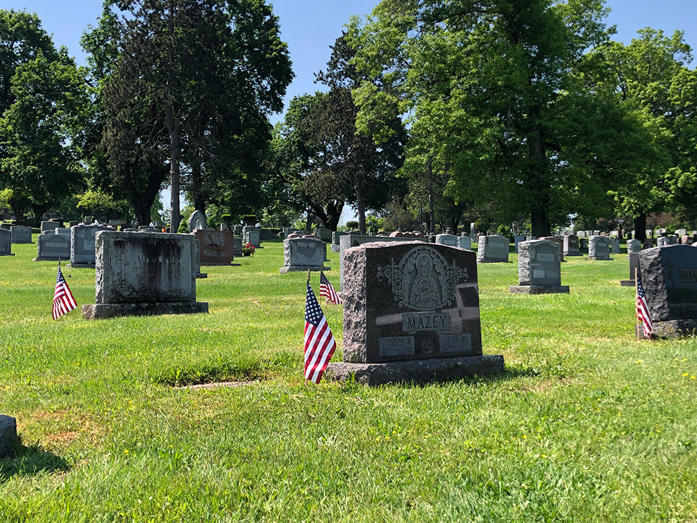 A small American flag marks the final resting place of a veteran at Cedar Hill Cemetery.